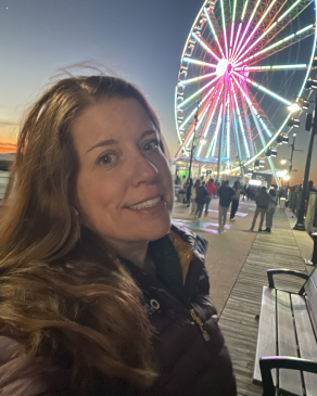A selfie of Rachel next to a Ferris wheel. 