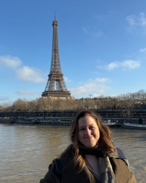 A photo of Angela in front of the Eiffel tower. 