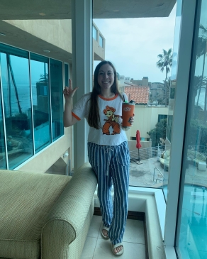 A photo of Andi standing next to a window. 