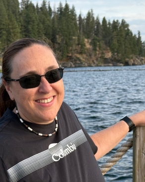 A photo of Lori overlooking a lake. 