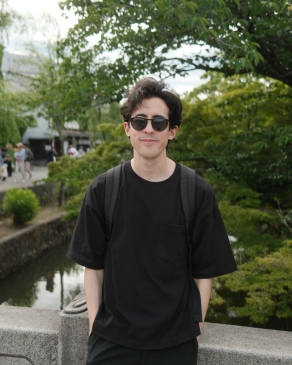 A photo of James next to a tree. 