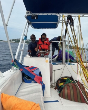 A photo of Jennifer steering a boat. 