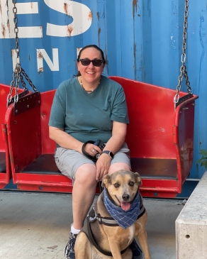 A photo of Lori and her dog sitting on a bench. 