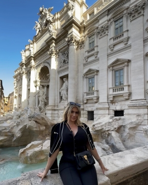 A photo of Larisa sitting near a historic building. 