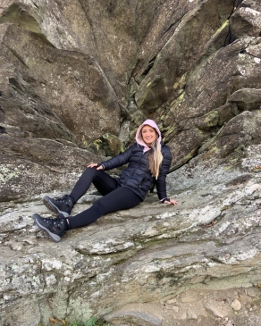 A photo of Jada leaning on a rocky hill. 