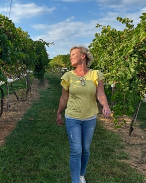 A photo of Missy walking through a path at a winery. 