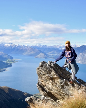 A photo of Kylie standing on a cliff. 