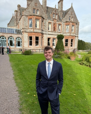 A photo of August posing near a historical building. 