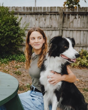 A photo of Taylor and a dog sitting on a bench. 