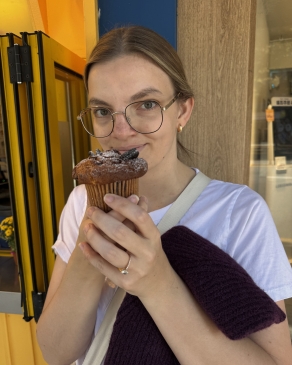 A photo of Emily eating a muffin. 