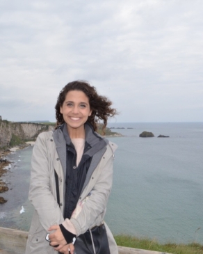 A photo of Tiffany posing in front of the ocean in Ireland. 