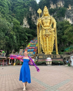 A photo of Lex posting with a statue in Malaysia. 