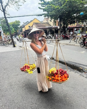 A photo of Lex holding fruit in Vietnam. 