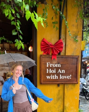 A photo of Lex next to a sign in Vietnam. 