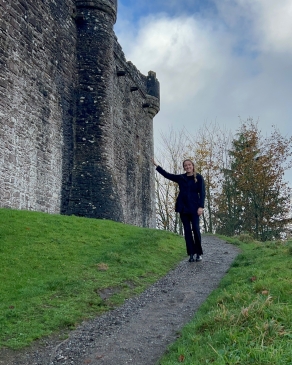 Meg posing next to an ancient castle. 
