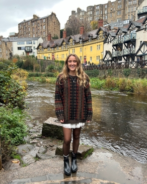 Meg posing next to distinctive homes. 
