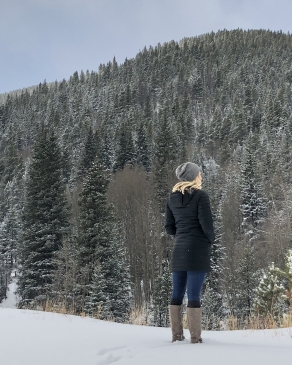 A woman looking on to the distance of the Rockies.