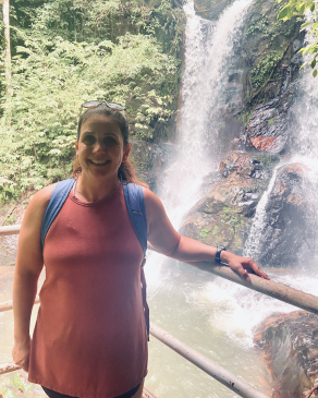 A photo of Whitney with a waterfall behind her. 