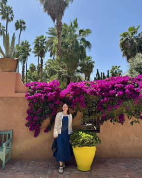 Fiona posing near a wall of flowers in Morocco. 