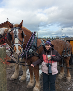 Kim taking a photo with a horse in Banff. 