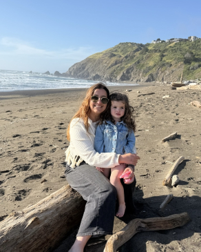 A photo of Jessica and a child on the beach in California. 